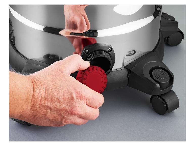 Hand schraubt einen roten Verschluss auf einen silberfarbenen Staubsauger.