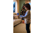 Ein Kind spielt mit einem leuchtend blauen fliegenden Ball in einem gemütlichen Weihnachtswohnzimmer.