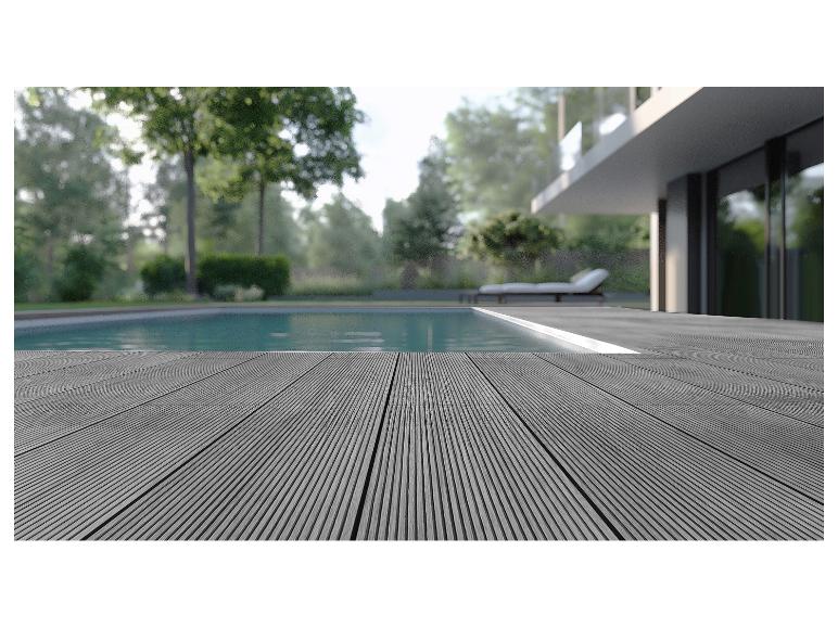Graue Verbundterrasse am Pool mit modernem Haus im Hintergrund.