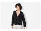Eine Frau trägt einen schwarzen Strickcardigan mit Knöpfen.