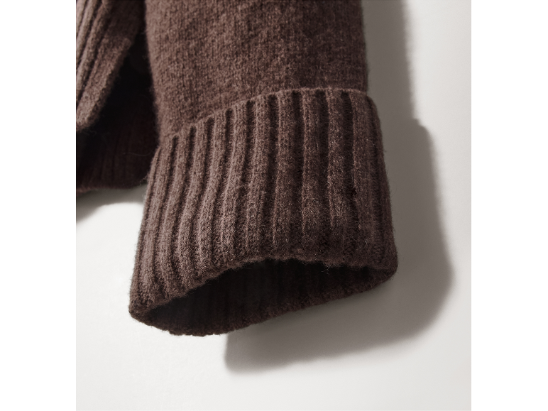 Nahaufnahme eines braunen Strickbündchens eines Pullovers.