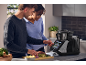 Paar kocht mit einer intelligenten Küchenmaschine, bereitet Gemüse zu.