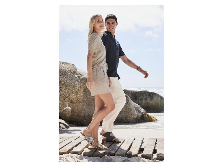 Paar mit Birkenstock Sandalen am Strand.