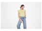 Frau in gelbem Kurzarmshirt und weiter Jeans.