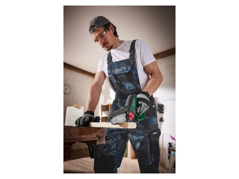 Ein Mann verwendet eine Parkside Kettensäge zum Holzschneiden.