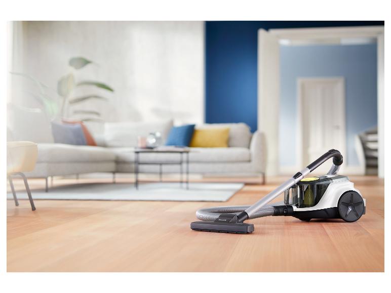 Staubsauger auf Holzboden in einem modernen Wohnzimmer mit Sofa und Couchtisch.