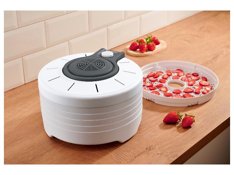 Weißer Dörrautomat mit frischen und getrockneten Erdbeeren in einer Küche.