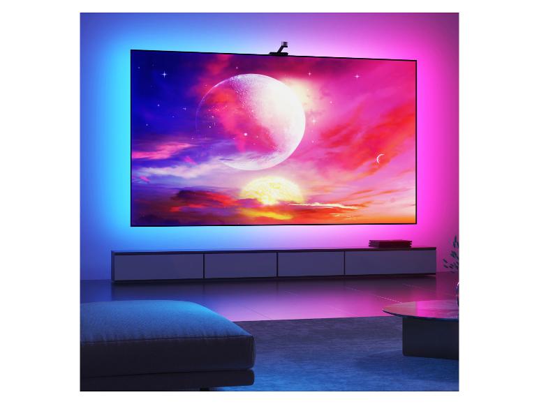 Großer Fernseher mit Umgebungsbeleuchtung, der eine lebendige Weltraumszene in einem modernen Wohnzimmer zeigt.