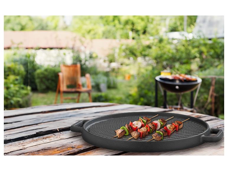 Fleisch- und Gemüsespieße auf einer GSW Black Iron BBQ 30cm runden Grillplatte im Garten.