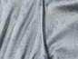 Ein weicher, grauer Stoff mit einer Naht.