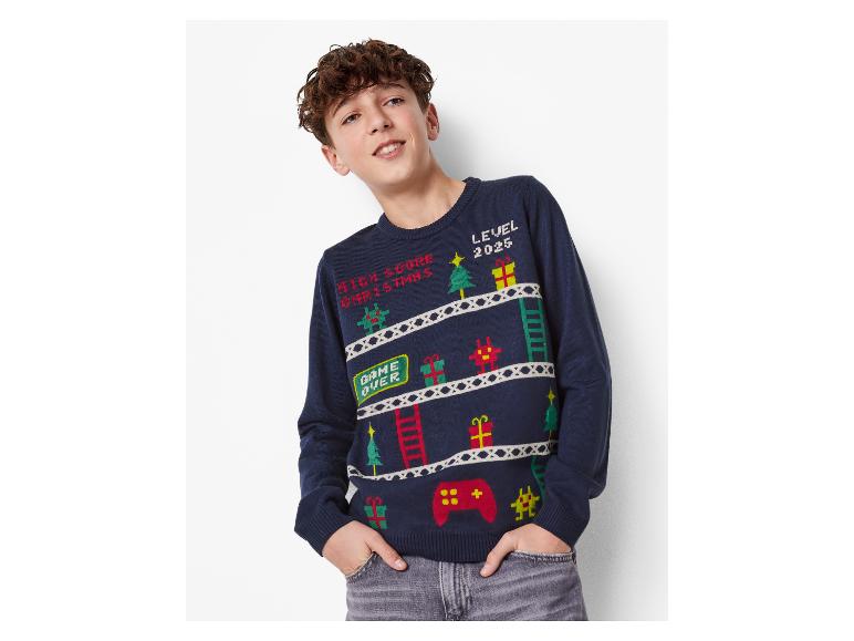 Junge in einem dunkelblauen Weihnachtspullover mit Videospiel-Motiv.