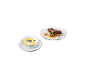 Schweinefilet mit Beilage und eine Joghurtschale mit Blaubeeren auf schwarzem Hintergrund.