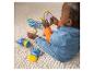 Baby spielt mit Zeichentrickfiguren und einem Spiegel auf einem Teppich.
