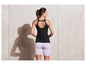 Eine Frau trägt ein schwarzes Tanktop und lila Fahrradshorts.