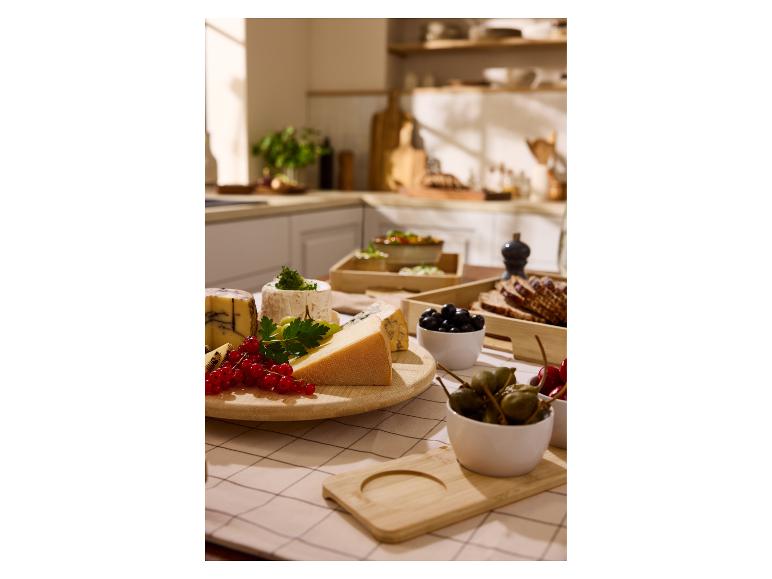 Eine Auswahl an Käse, Beeren und Oliven auf einem Küchentisch.