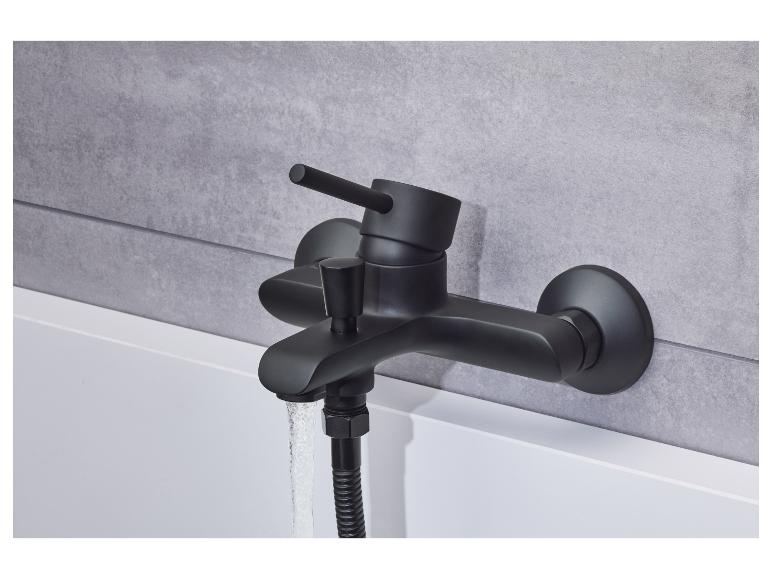 Ein schwarzer Badewannenmischer mit einer Duschbrause, befestigt an einer weißen Badewanne.