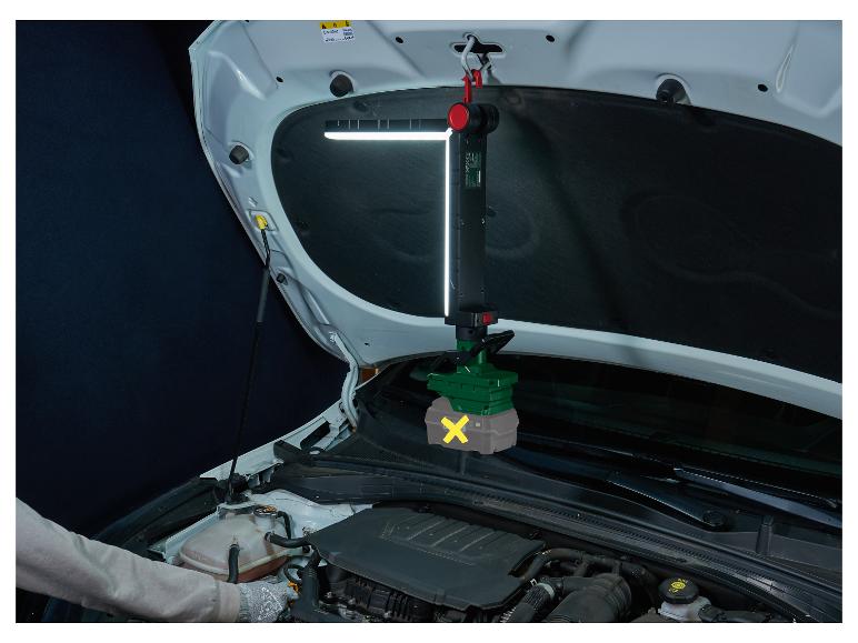 Ein Mechaniker arbeitet an einem Auto mit einer hängenden LED-Motorraumleuchte.