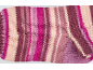 Gestreifter Strickstoff in Rosa-, Lila- und Cremetönen.