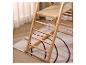 Holzleiter mit Ablage, auf einem Teppich mit geometrischem Muster und hellen Vorhängen.