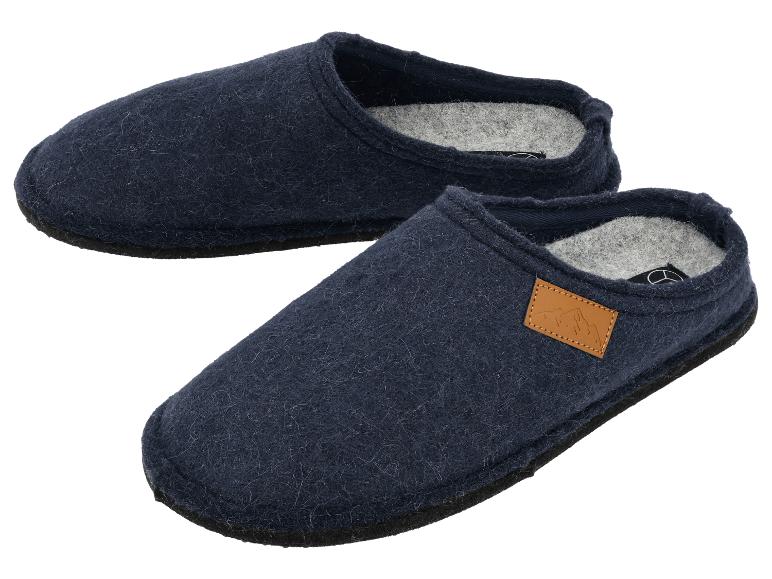 Ein Paar dunkelblaue Filzpantoffeln mit einem hellbraunen Lederdetail.