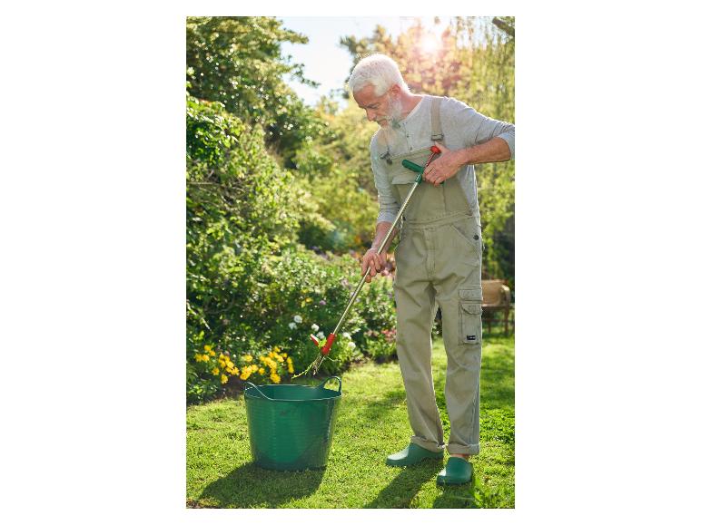 Ein Mann verwendet eine Unkrautzange, um Unkraut aus seinem Garten zu entfernen.