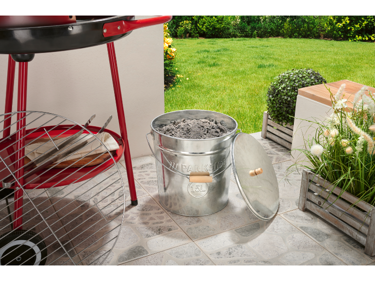 Roter Grill mit 15L Ascheeimer und Zubehör auf einer Terrasse.