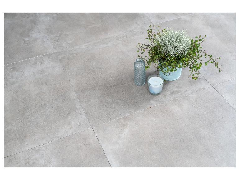 Graue Fliesen mit Topfpflanze, Vase und Kerze.