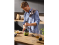 Ein Mann benutzt einen Stabmixer, um in der Küche Pesto zuzubereiten