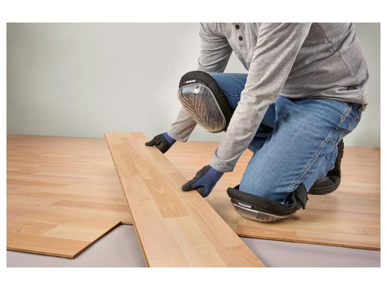 Person mit Parkside Knieschonern verlegt Laminatboden.