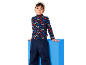 Kind in Rollkragenpullover mit Bergmuster und dunkelblauer Skihose.