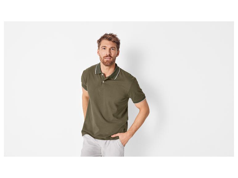 Männliches Model in olivgrünem Poloshirt und beigefarbener Hose.