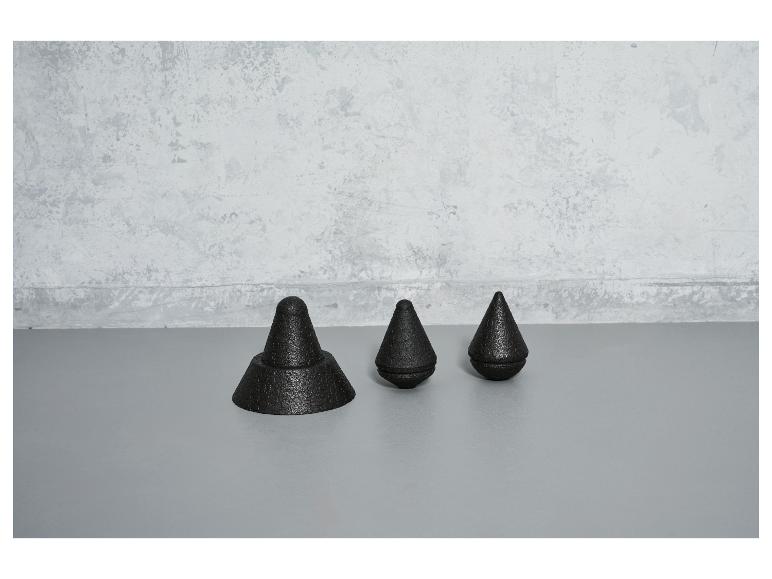 Drei schwarze, kegelförmige Objekte auf einem grauen Boden.