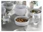 Gedeckter Tisch mit weißen Schalen Müsli und Obst sowie Wassergläsern.