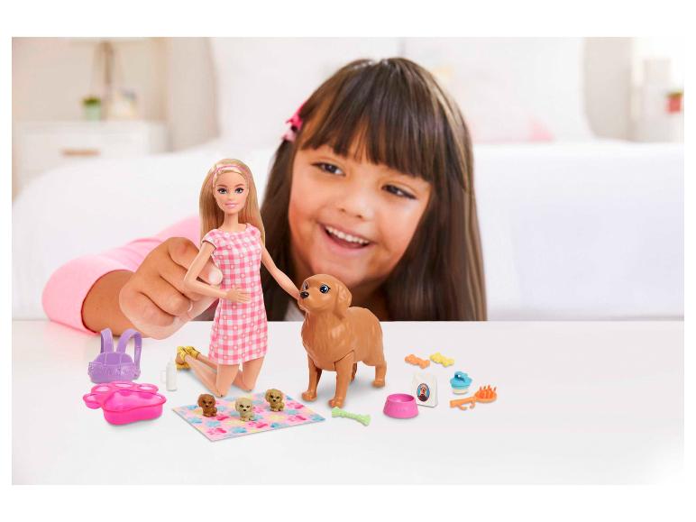 Barbie-Puppe und Hundespielzeug mit einem spielenden Mädchen im Hintergrund.