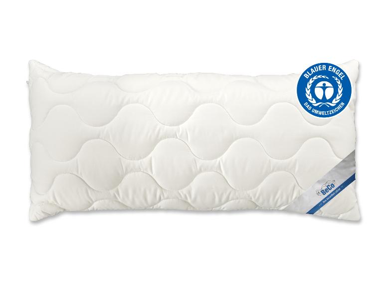Weißes Kissen mit Wellensteppung und blauem Umweltzeichen.