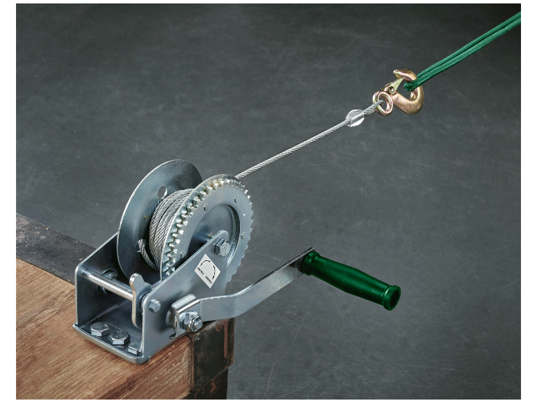 Eine Handwinde mit Stahlseil, das an einem Haken befestigt ist.