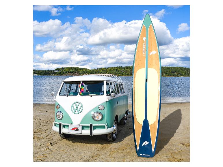 Ein Vintage Volkswagen T1 Bus am Strand mit einem Boardsportz Paddleboard.