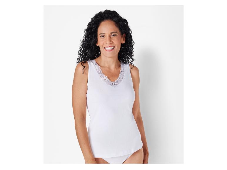 Eine Frau trägt ein weißes Tanktop mit Spitzendetails.