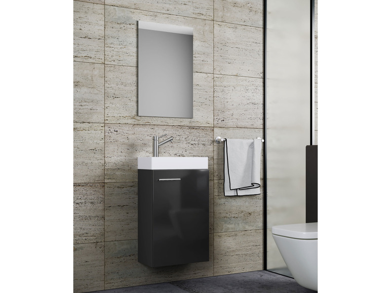 Ein schwarzes Badezimmermöbel mit Spiegel und Waschbecken.