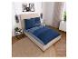 Schlafzimmer mit Bett, blauer gestreifter Bettwäsche, zwei Beistelltischen und Wanddekoration.