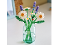 Ein Strauß Bausteinblumen, Gänseblümchen und Lavendel, in einer Glasvase.
