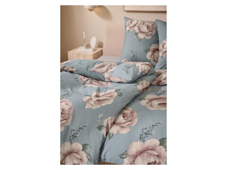 LIVARNO home Jersey-Spannbettlaken auf einem Bett mit geblümter Bettwäsche