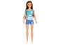 Eine Barbie-Puppe mit einem türkisfarbenen T-Shirt mit Palmen und Jeans-Shorts.