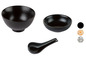 Zwei schwarze Schalen und ein Suppenlöffel.