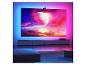 Großer Fernseher mit Umgebungsbeleuchtung, der eine lebendige Weltraumszene in einem modernen Wohnzimmer zeigt.