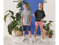 Zwei Kinder tragen T-Shirts und Shorts mit 'Champ' und 'Travel the World' Prints.