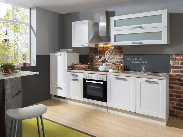 Weiße Küche mit Backofen, Spüle und Schränken.