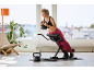 Eine Frau macht Rückenstrecker-Übungen auf einer verstellbaren Hantelbank mit einer Kettlebell.