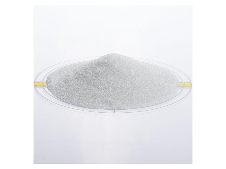 Haufen weißen Sandes auf einer transparenten Schale mit gelbem Maßband