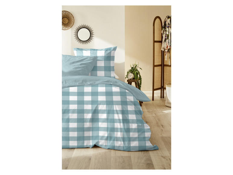 Eine blau-weiße karierte Bettdecke auf einem Bett.